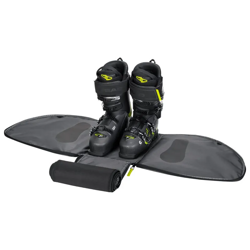 Head Skischuhe in geöffneter Bootbag Tasche. Die Tasche ist grau und die Skischuhe sind schwarz mit gelben Akzenten.
