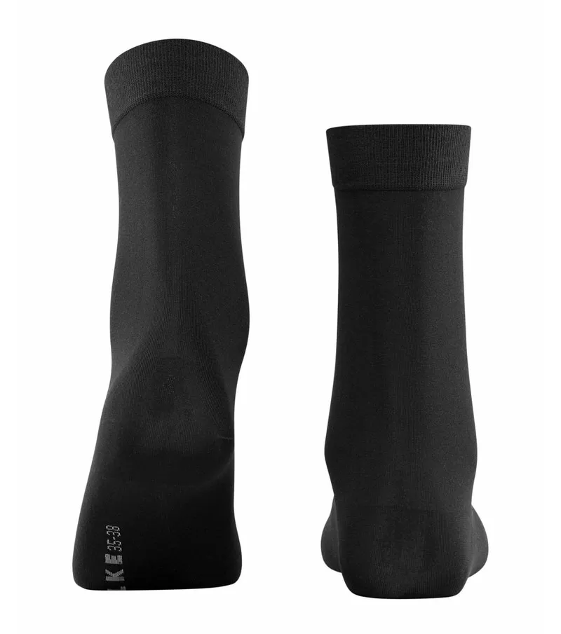 Two black cotton ladies' socks, standing upright.
