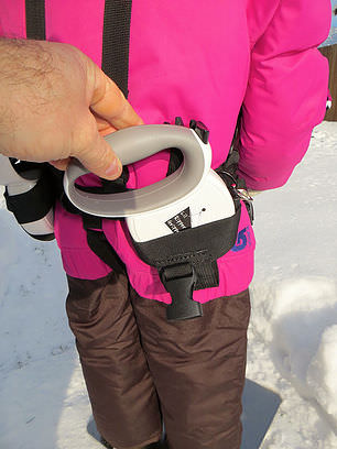 Gros plan de la ceinture Lil' Ripper Gripper sur l'enfant, avec la main sur la poignée et le détail de la laisse rétractable.