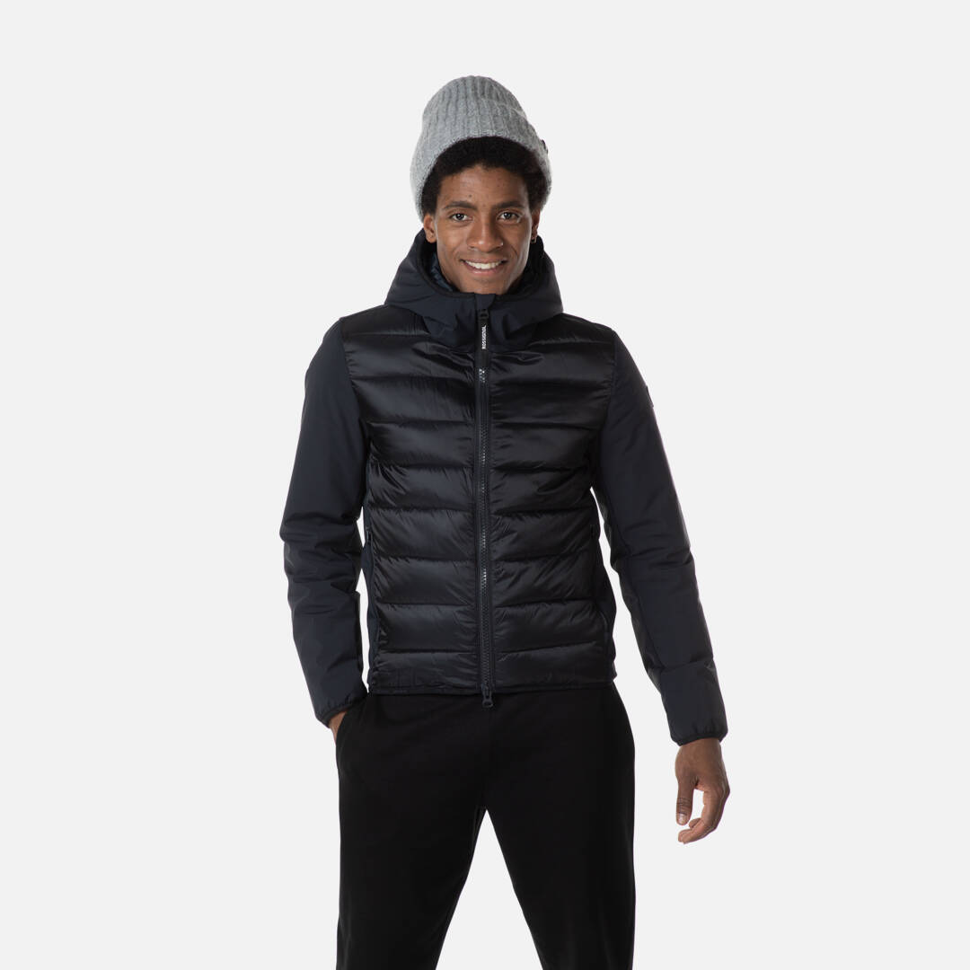 Rossignol Hoodie für Männer Ein Mann mit Mütze, trägt eine schwarze Rossignol Stretch Quilt Hoodie Jacke mit Kapuze.
