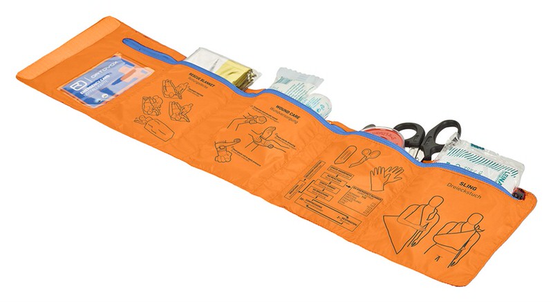 Ausgebreitetes, oranges First Aid Roll Doc Set mit Inhalten und Anleitungen für alpine Notfälle.