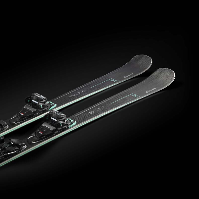 Zwei Nordica Belle DC 72 Ski diagonal, mit montierten Bindungen, vor schwarzem Hintergrund.