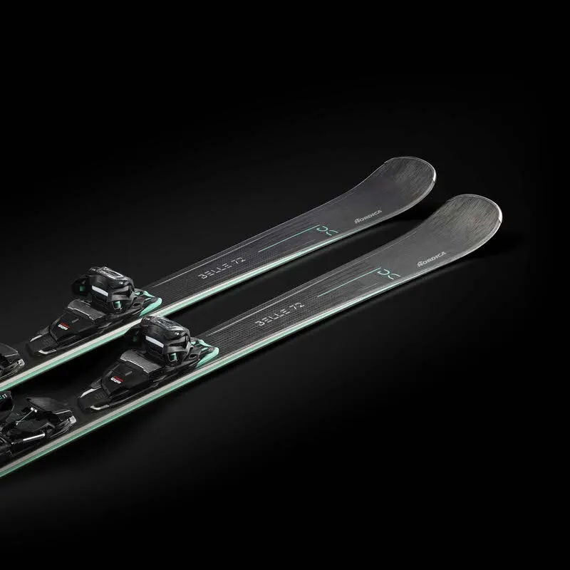 Zwei Nordica Belle DC 72 Ski diagonal, mit montierten Bindungen, vor schwarzem Hintergrund.