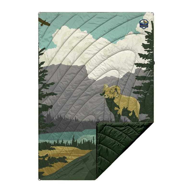 Gesteppte Rumpl Puffy Blanket mit Rocky Mountain Motiv, zeigt Berglandschaft, Widder, Baum und Vogel.