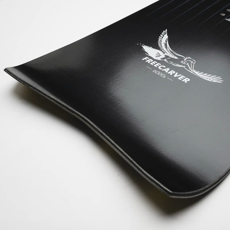 Schwarzes Jones Snowboard Detailaufnahme der Spitze eines schwarzen Jones Freecarver Snowboards mit weißem Vogel-Logo.