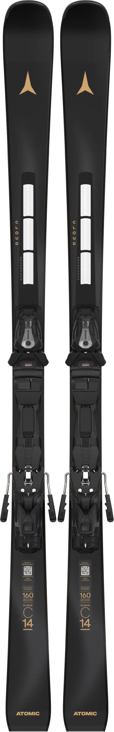 Two black Atomic skis with mounted bindings, arranged vertically with the tips pointing upwards. Golden accents and white stripes are visible.