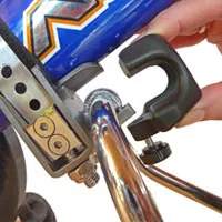 Close-up: FollowMe Children's tandem clutch attached to the children's bike. Black bracket is attached to silver bar.