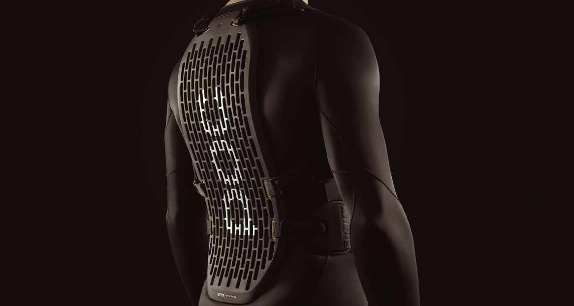Schwarzer Neoprenanzug Schwarzer Neoprenanzug mit belüftetem, grauem Rückenprotektor, der an Schultern und Taille befestigt ist. Der Hintergrund ist dunkel und einfarbig.