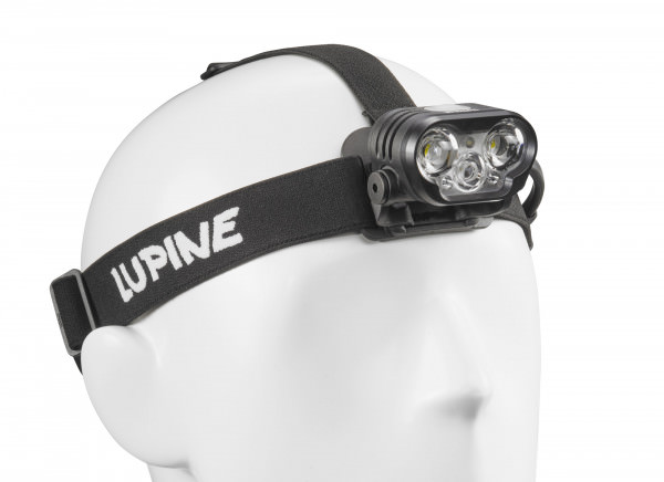 Nahaufnahme einer Blika RX 7 Stirnlampe auf einem weißen Dummy-Kopf. Das Stirnband trägt den Schriftzug "Lupine".