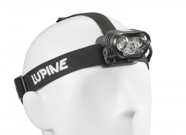 Nahaufnahme einer Blika RX 7 Stirnlampe auf einem weißen Dummy-Kopf. Das Stirnband trägt den Schriftzug "Lupine".