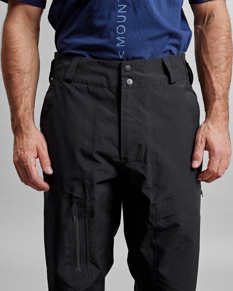 Schwarze GORE-TEX Hose Schwarze GORE-TEX Pro Shell Hose am Körper, Bund mit zwei Knöpfen, zwei Beintaschen mit Reißverschluss.