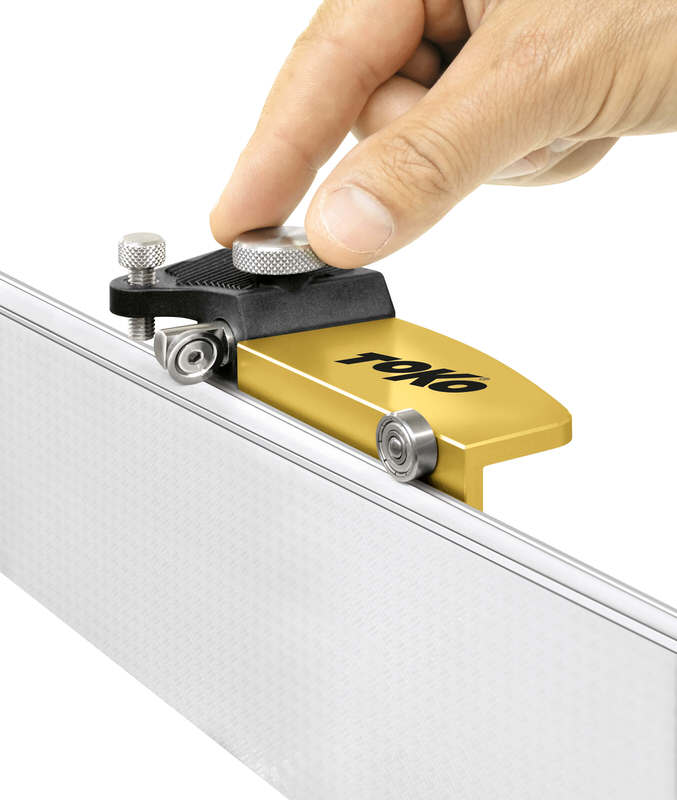 Hand justiert Toko Sidewall Planer World Cup an einer Ski-Seitenwange. Goldfarbenes Werkzeug mit Stellrädern und Toko-Logo.