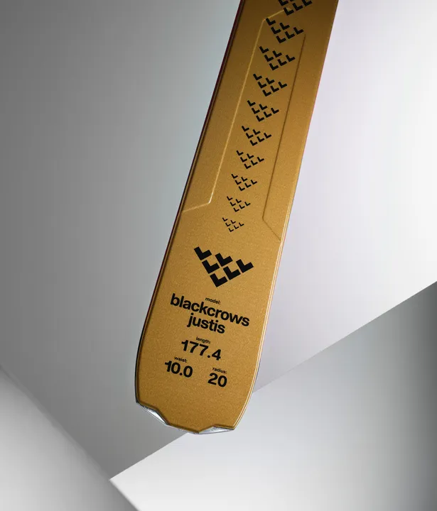 Detailansicht Skiende vom Black Crows Justis mit Logo und technischen Daten auf goldener Oberfläche.
