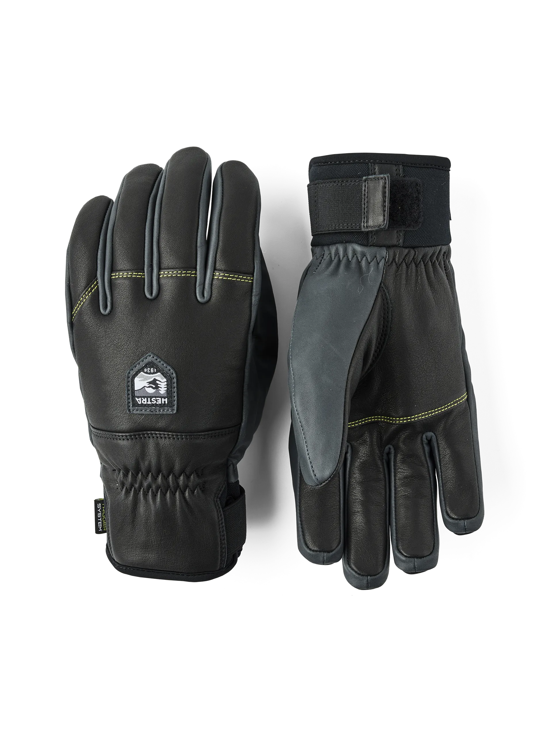 Zwei schwarze Hestra Omni Trigger Handschuhe, einer mit sichtbarem Handgelenkbund, auf weißem Grund.