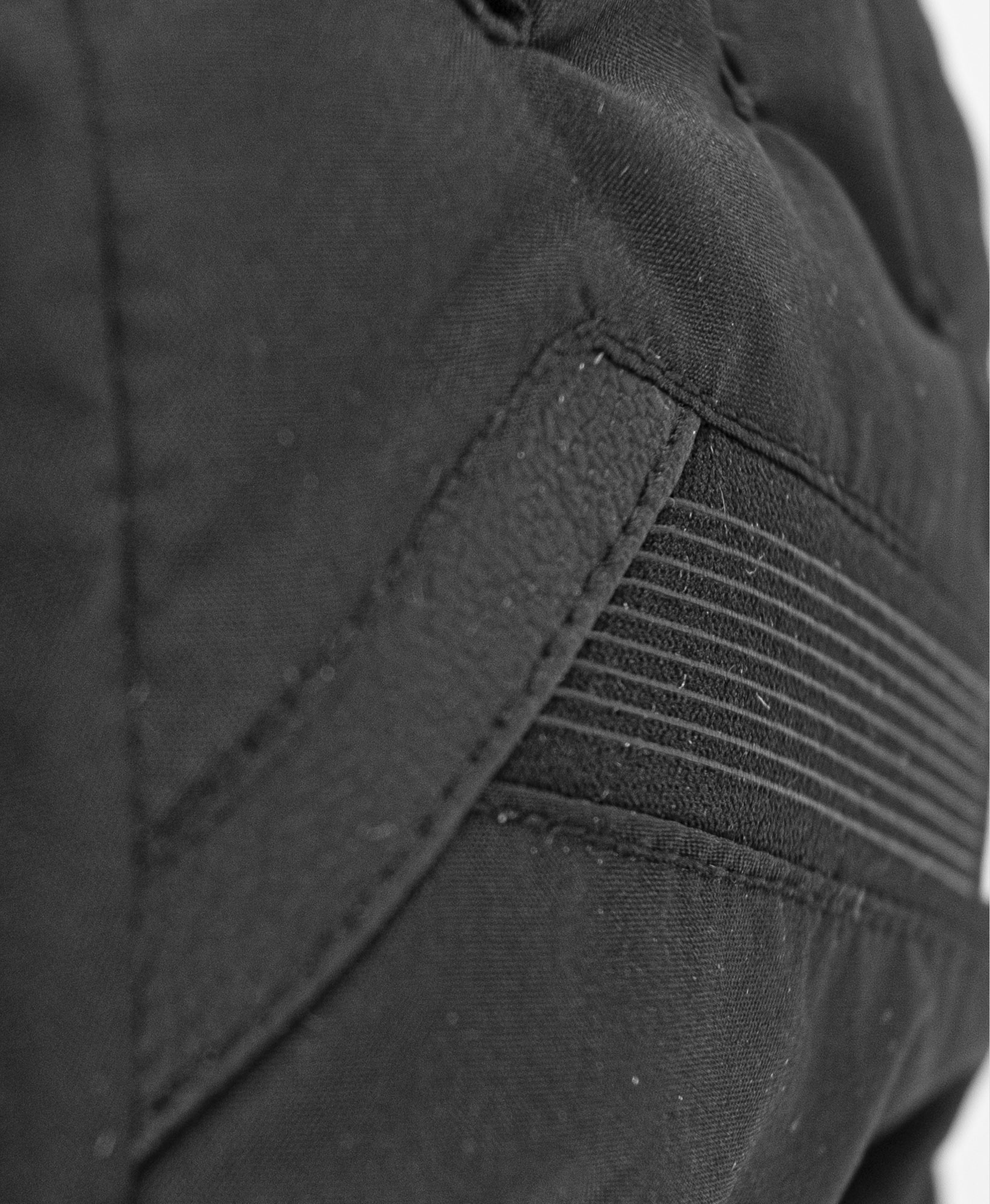Detailaufnahme eines schwarzen Reusch Flash GORE-TEX JR Handschuhs, texturiertes Material.