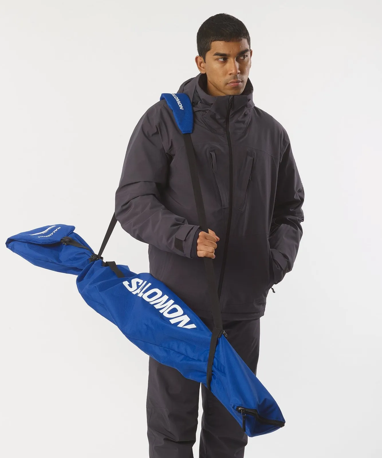 Man with ski bag: Blue Salomon ski bag over the shoulder, carried by a person in winter clothing.