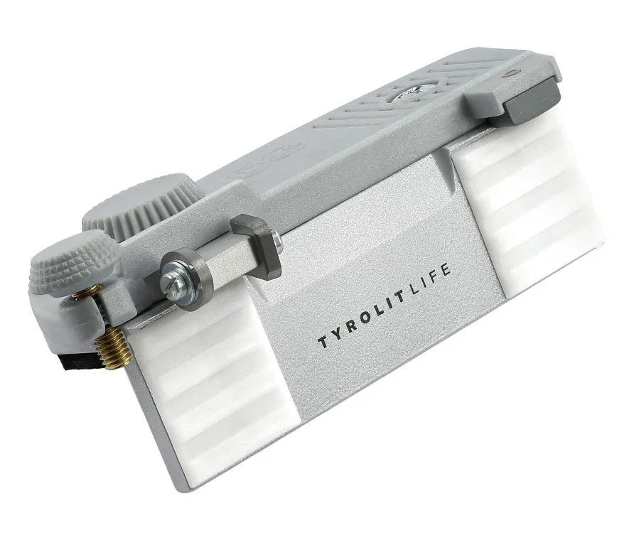 Primo piano di un utensile Tyrolit LIFE grigio con strisce orizzontali bianche su una superficie bianca.