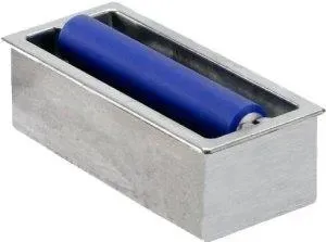 Rectangular, shiny metal bowl with slightly raised edges and a smooth surface. In the center lies a cylindrical, dark blue roll, almost as long as the bowl, uniform in shape, with slightly rounded ends.
