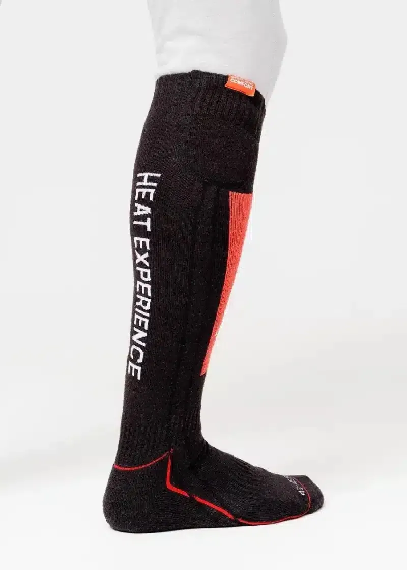 Un calzino nero lungo con "Heat Experience" in bianco sul lato, accenti rossi e una piccola etichetta arancione.