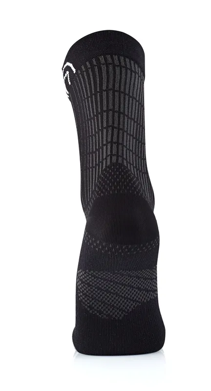A black sock with a light gray grid pattern, photographed from behind, standing on a white, shiny surface.