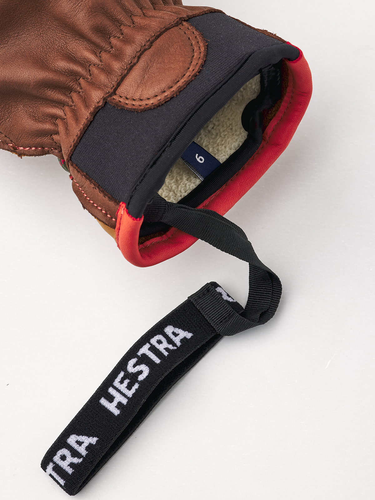 Hestra Wakayama Handschuh Nahaufnahme eines Hestra Wakayama Handschuhs mit Wollfutter, Größenetikett und Handschlaufe auf weißem Hintergrund.