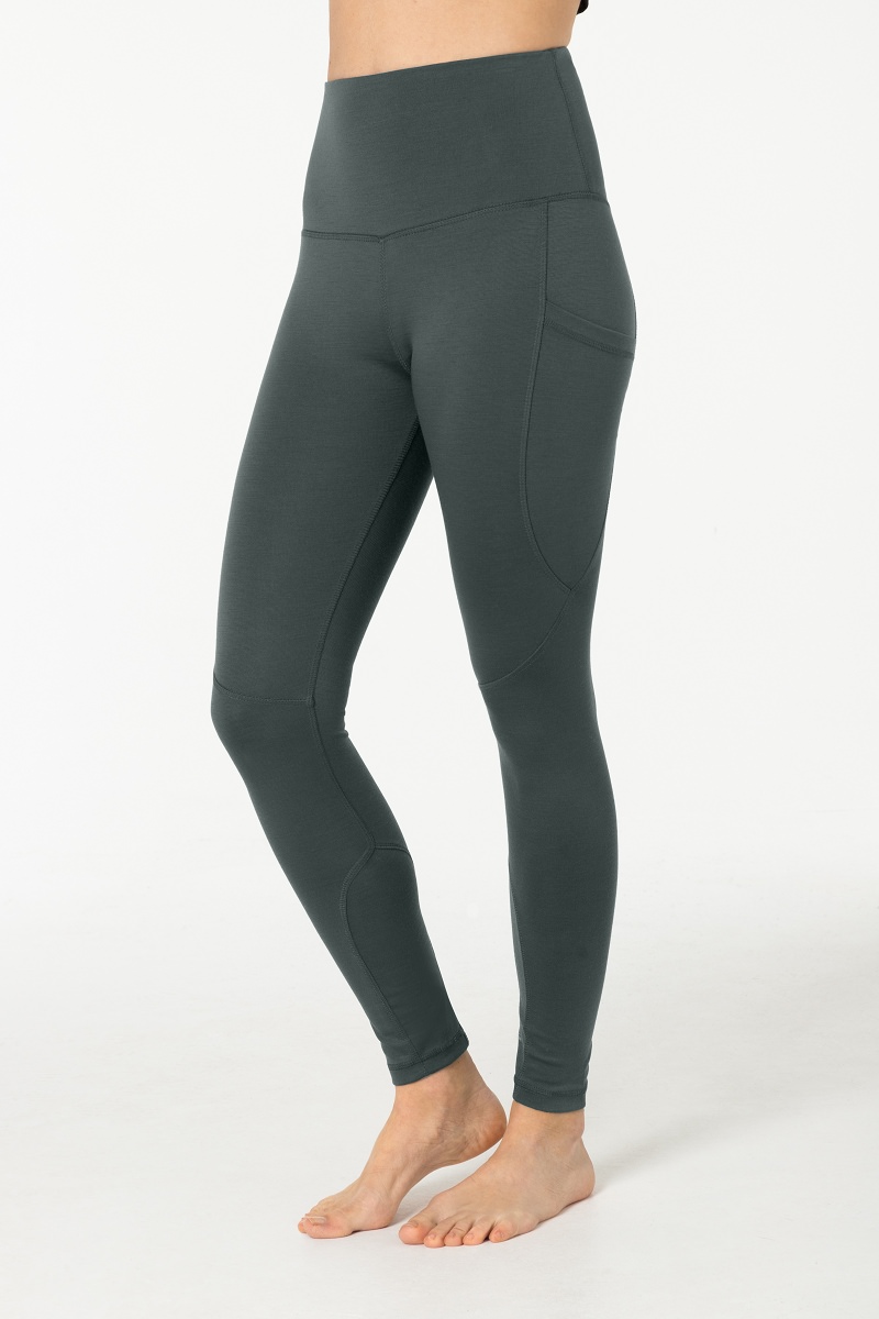 Graue Super.Natural Favourite Tights mit Seitentasche, an einer Person getragen, vor einem weißen Hintergrund.