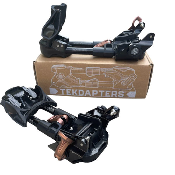 Deux adaptateurs Daymaker Tekdapters Ski Touring devant un carton portant le logo Tekdapters.