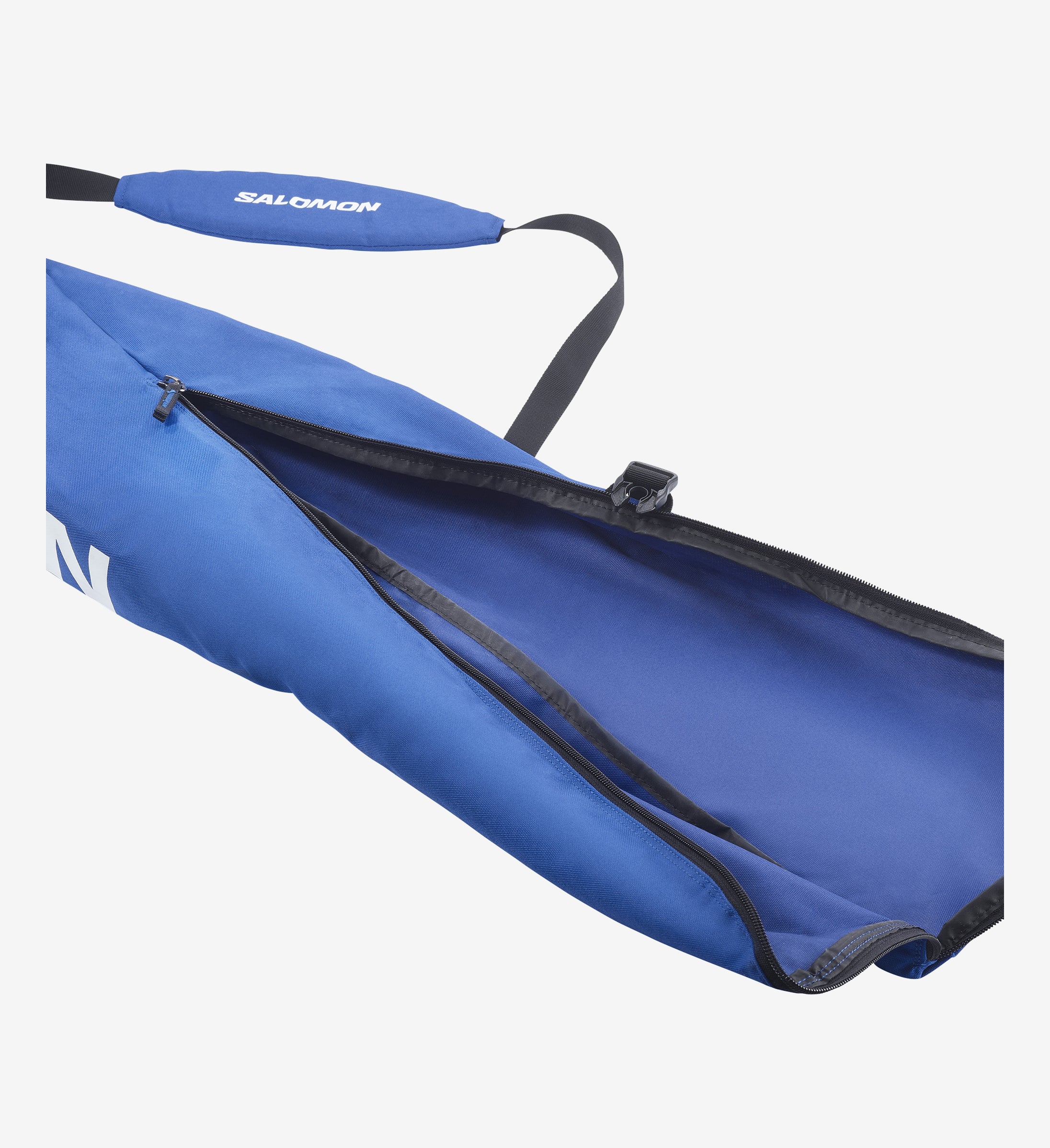 Sac à skis bleu ouvert de Salomon, avec sangle de transport. Fermeture éclair visible, intérieur du sac bleu.