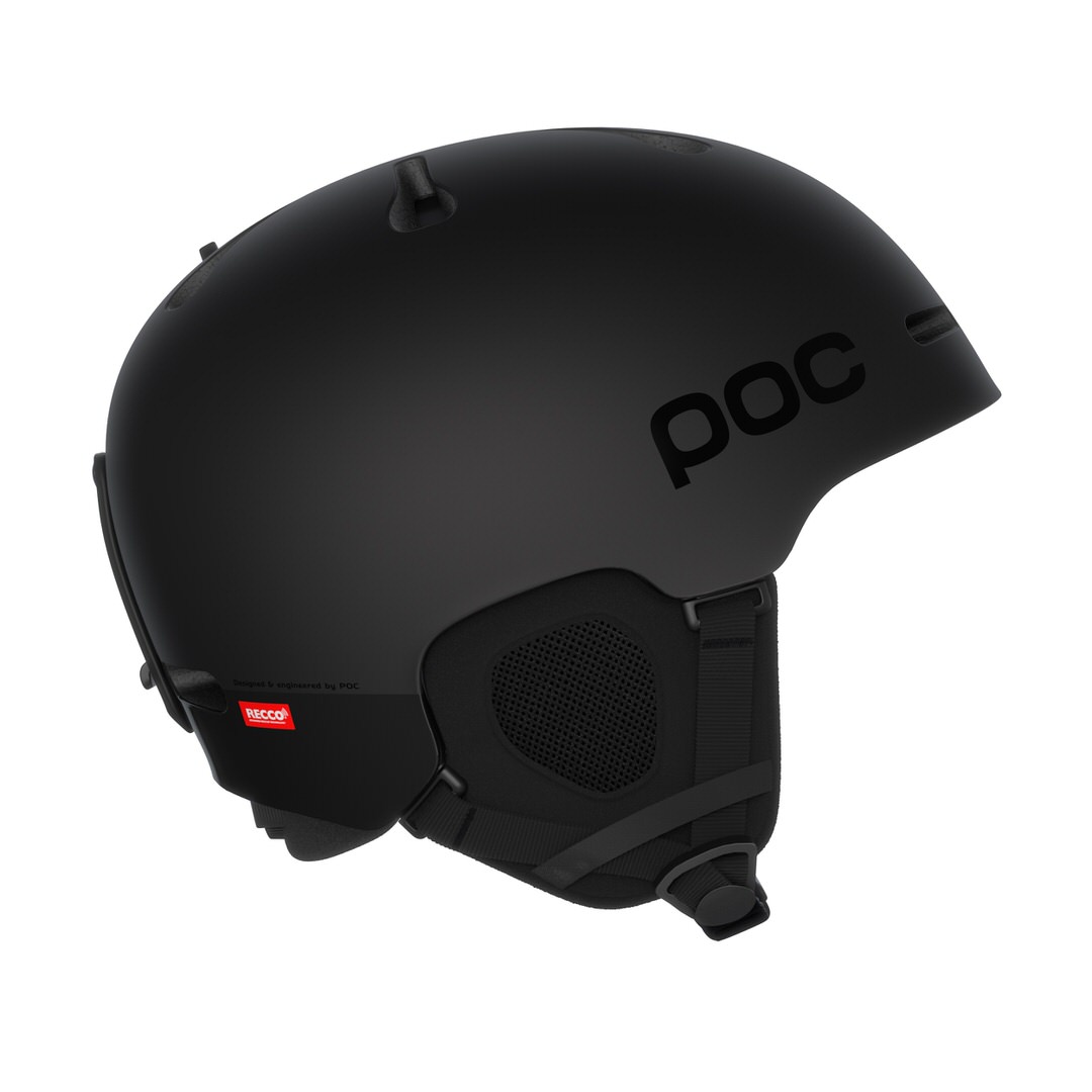 Ein mattschwarzer Skihelm (POC Fornix BC MIPS) von der Seite mit Belüftungsschlitzen, RECCO Reflektor und Ohrenpolstern.