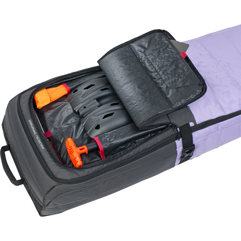 Geöffnete Evoc Snow Gear Roller XL Tasche, bepackt mit Ski-Helmen und Lawinenausrüstung.