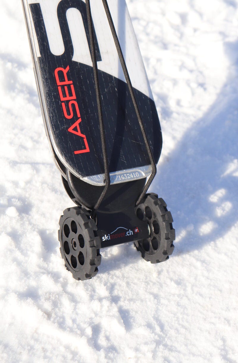 Ski mit schwarzem Skimover Easy auf Schnee, der Ski wird durch ein Band gehalten, unter dem Ski sind Räder.