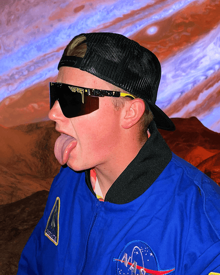 Astronaute avec lunettes de soleil Homme avec lunettes de soleil, langue sortie, en tenue d'astronaute sur fond d'espace. Cosmos 2000.