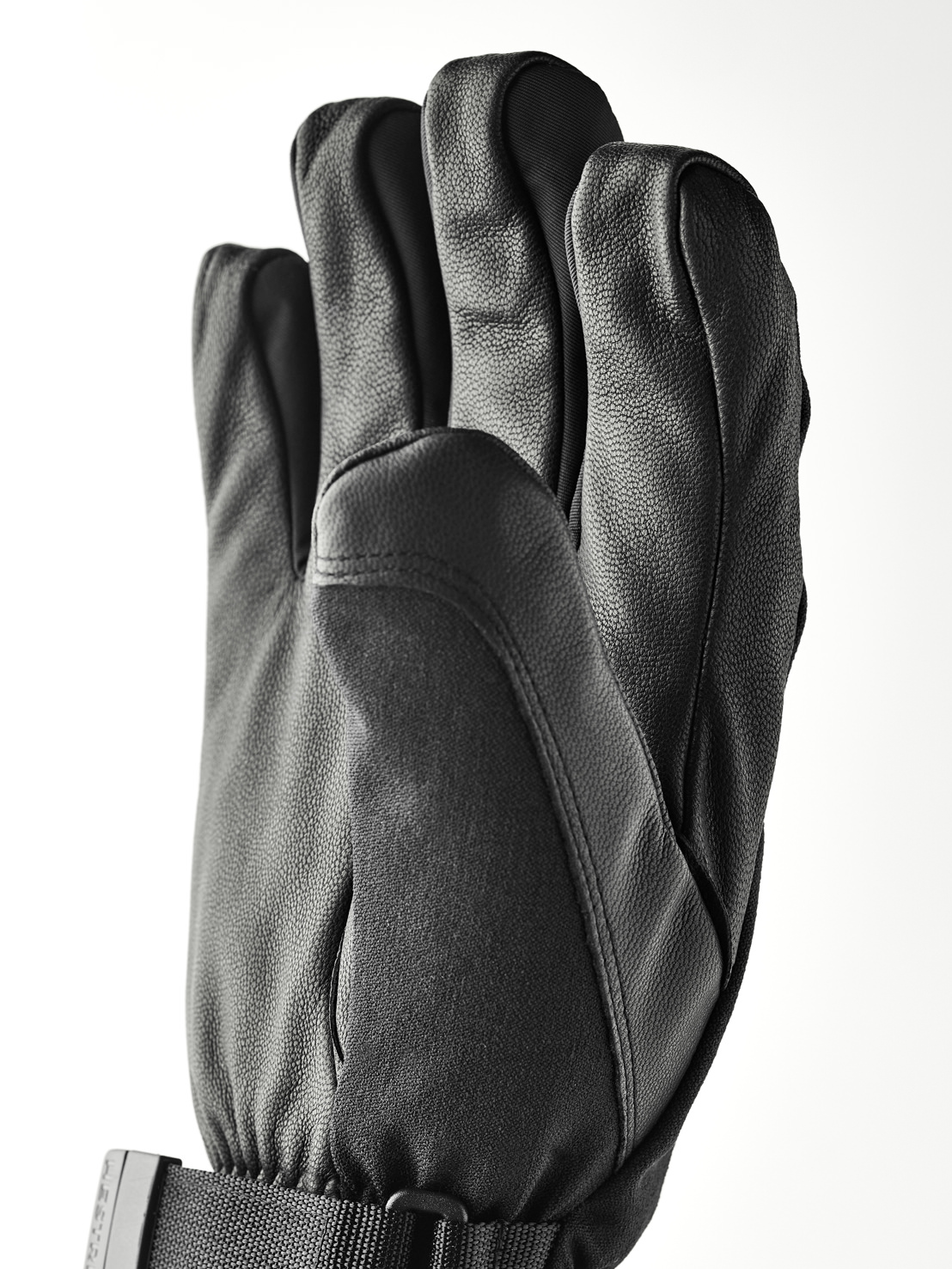 Gants en cuir noir Un gant en cuir noir à cinq doigts, avec une bande de poignet et une boucle.