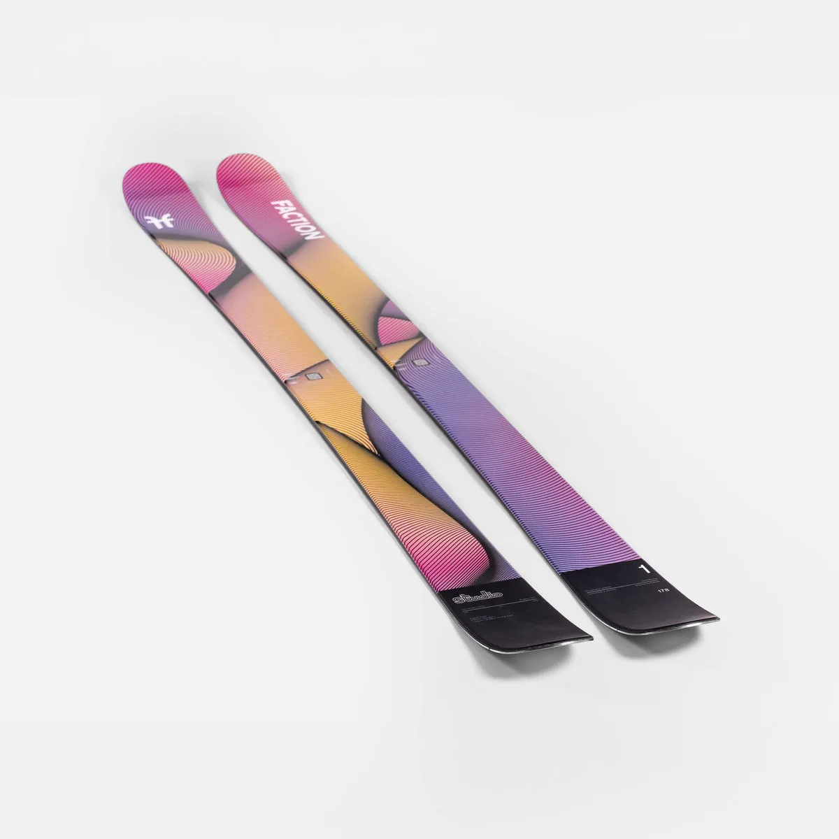 Two skis with a color gradient from pink to yellow and purple, placed diagonally next to each other on a white background.