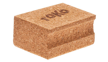 Quaderförmiger Toko Wachs Korken, beige, mit Logo und einer Griffmulde.