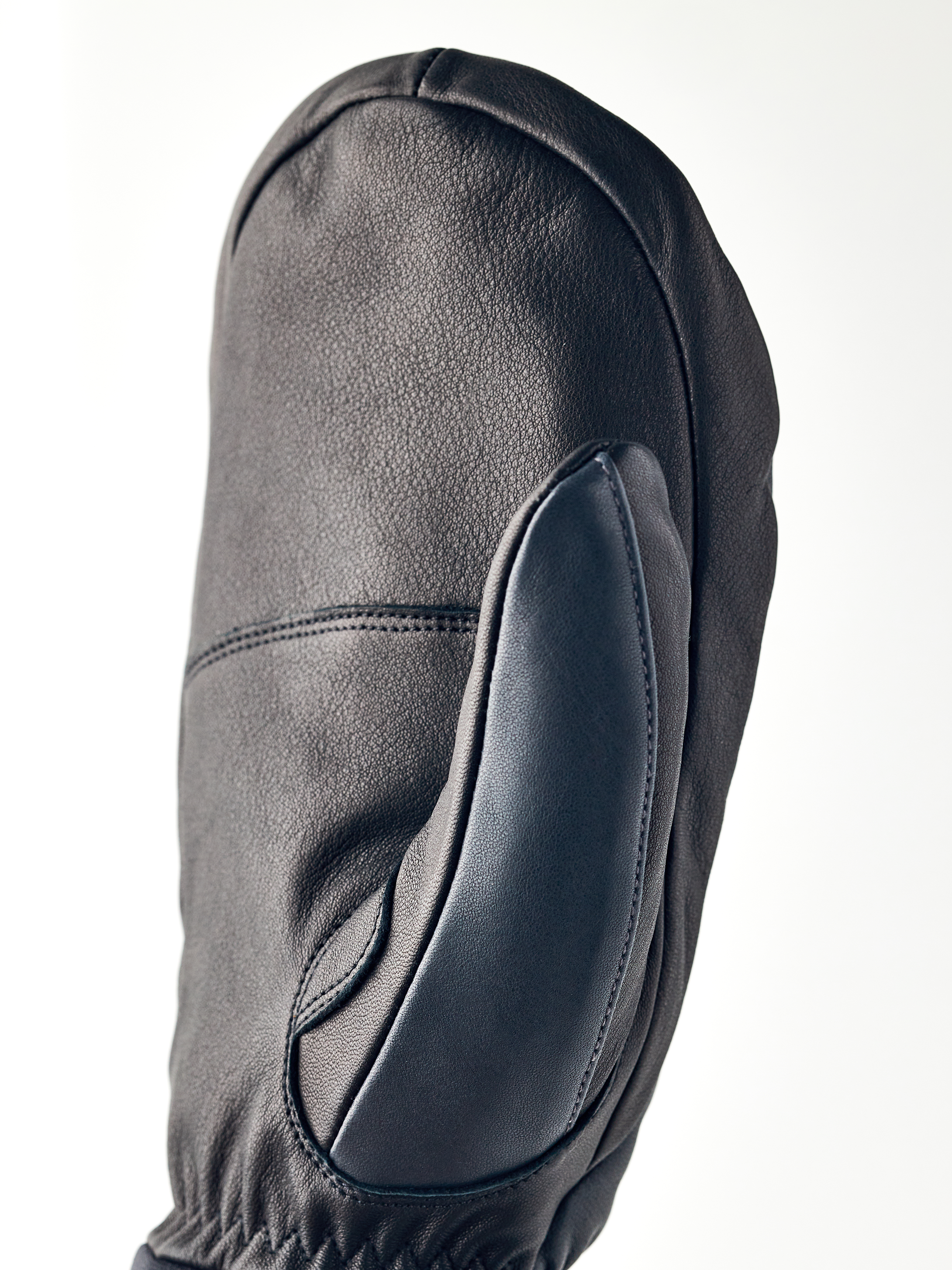 Schwarzer Lederhandschuh Nahaufnahme eines schwarzen Lederhandschuhs, Army Leather Wool Terry Mitt, mit sichtbaren Nähten und Textur.
