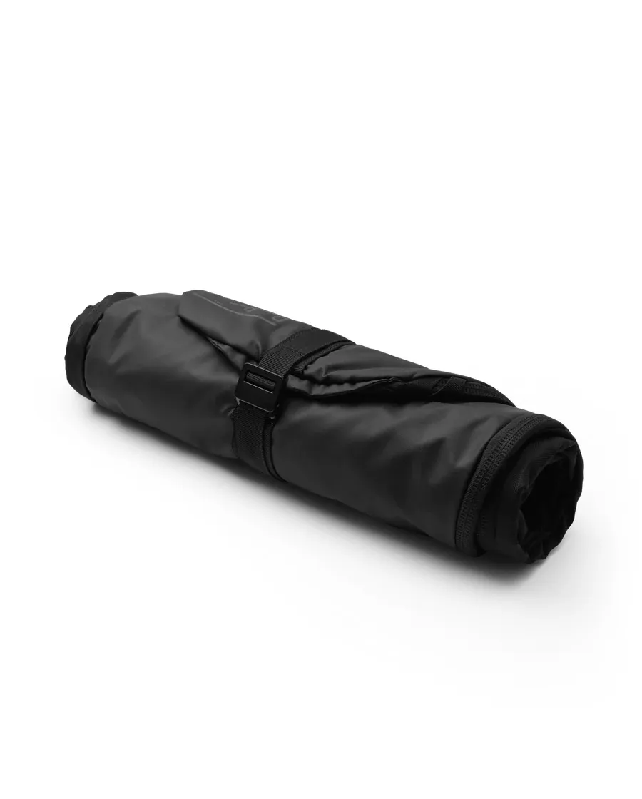 Rolled, black snowboard bag with strap and buckle on a white background.