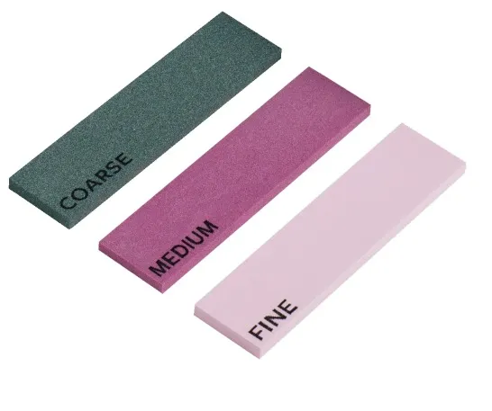 Tre pietre per affilare: grossa (verde), media (rosa), fine (rosa). Etichetta in lettere nere su ogni pietra.