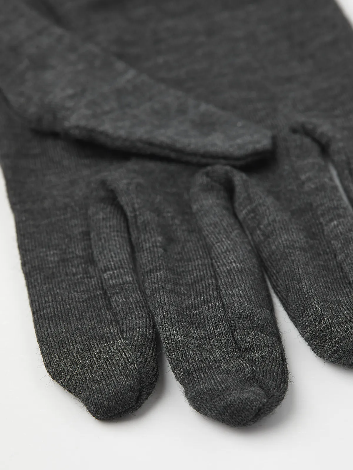 Primo piano di un guanto grigio Hestra Merino Wool Liner Active. È visibile il motivo a maglia strutturata.