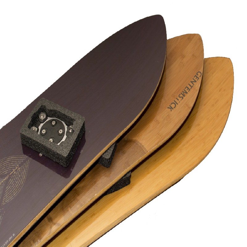 Drei Snowboards übereinander, das oberste mit Schutz für die Bindungsmontage, Holz-Snowboards sind mit "GENTEMSTICK" beschriftet.
