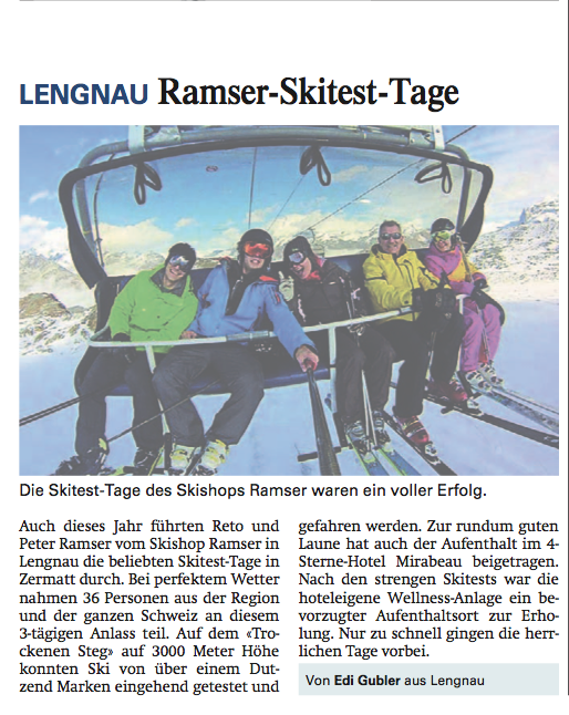 Groupe de cinq personnes à skis sur un télésiège devant des montagnes enneigées.