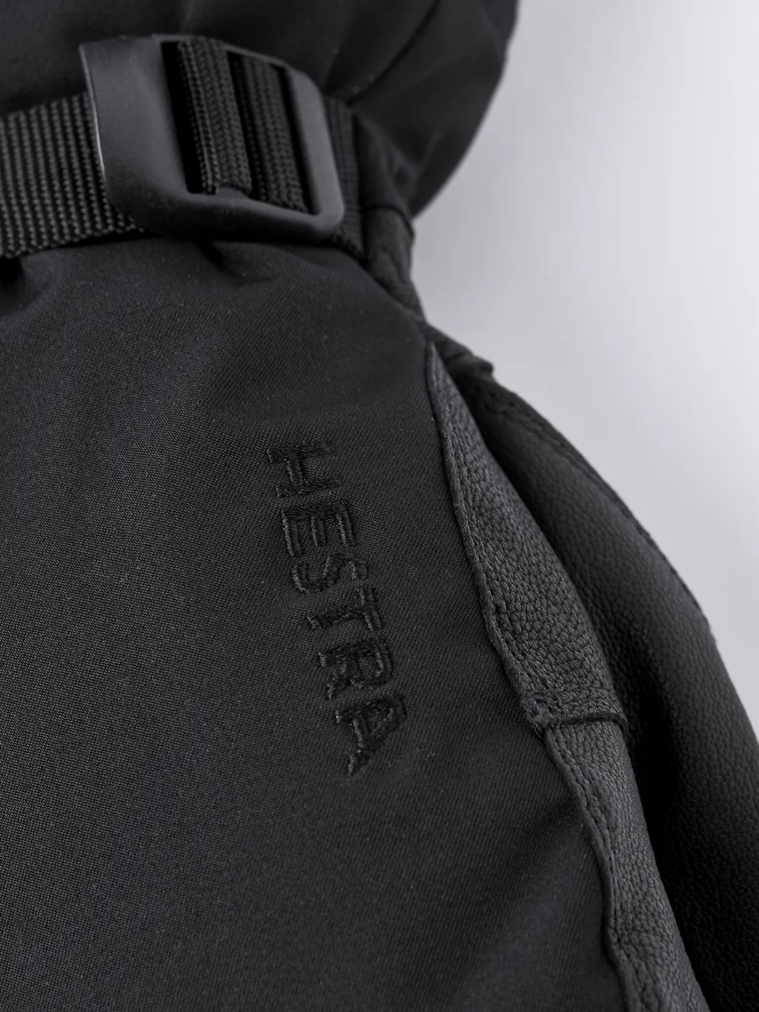 Vue détaillée de la mitaine noire Hestra Army Leather Extreme avec logo et lanière.