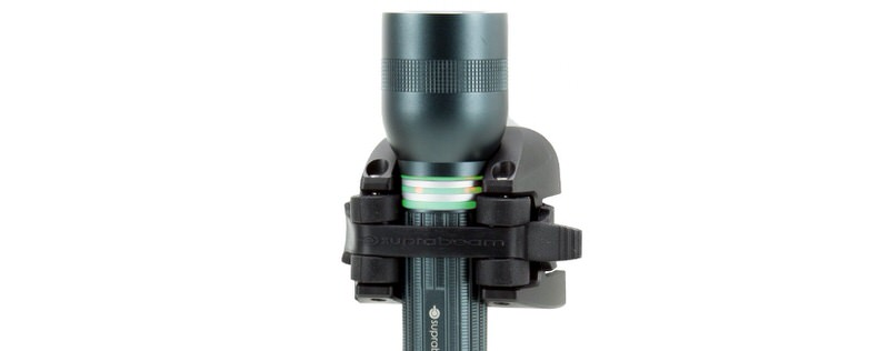 Lampe de poche à LED gris foncé Suprabeam Q5xr Defend, fixée dans un support noir, sur fond blanc.