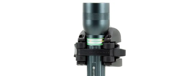 Dark gray Suprabeam Q5xr Defend LED flashlight, mounted in a black holder, against a white background.