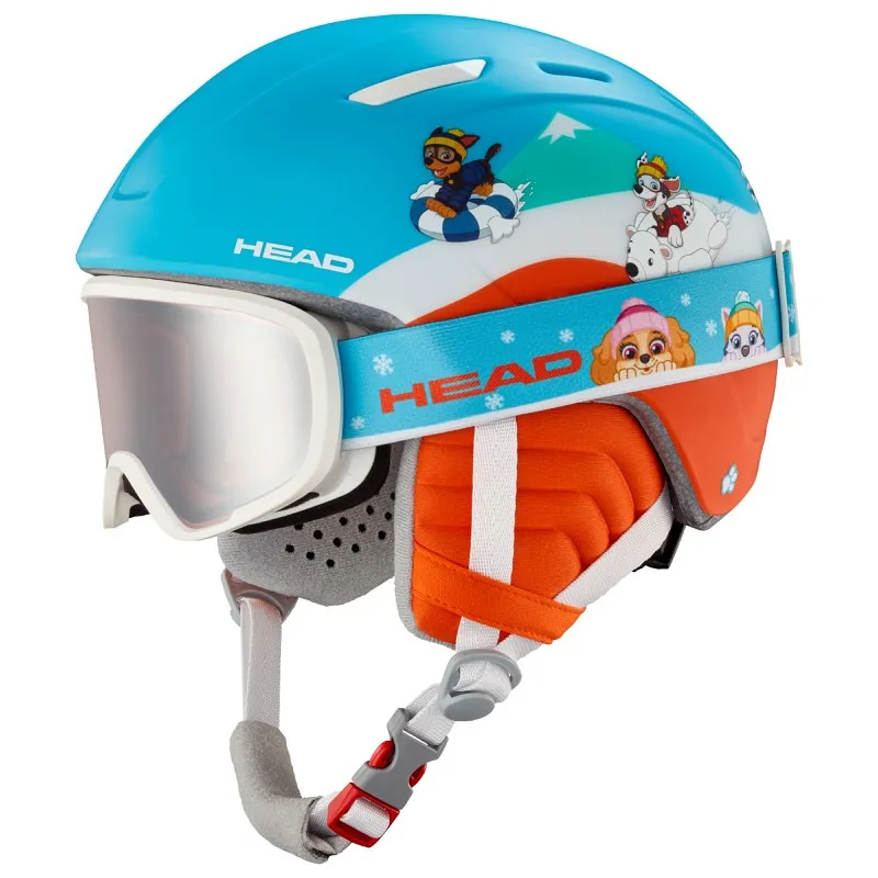 Blue children's ski helmet with Paw Patrol motifs and snow goggles. Orange details and chin strap are visible.