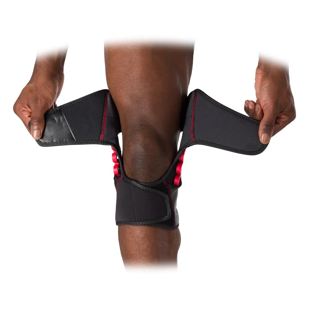 Close-up: Dark-skinned man putting on a MCDavid NRG Knee Over Wrap knee support, accentuated in red.