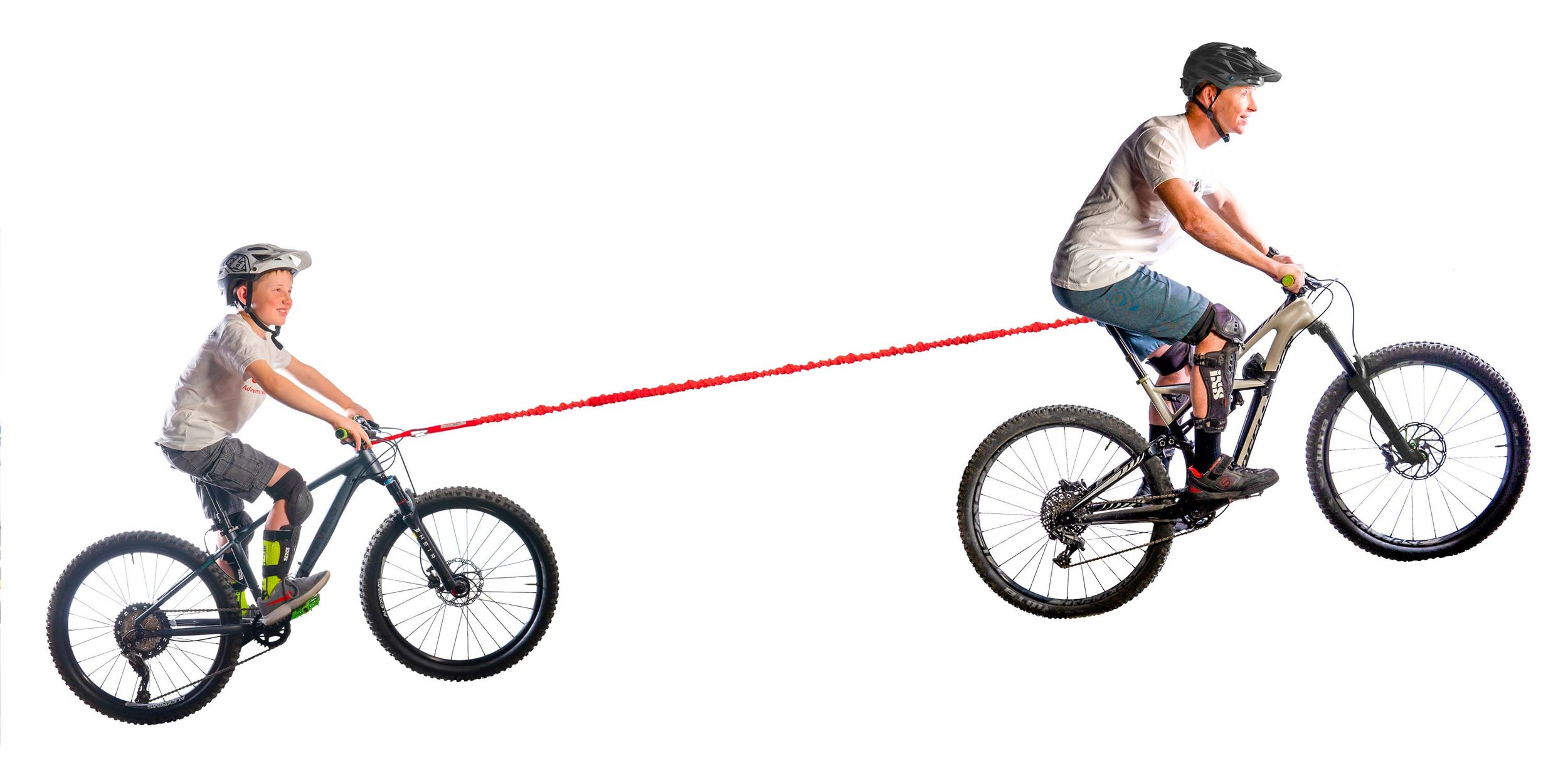 Vater zieht Kind mit TowWhee CONNECT am Fahrrad. Rotes Schleppseil verbindet die zwei Fahrräder.
