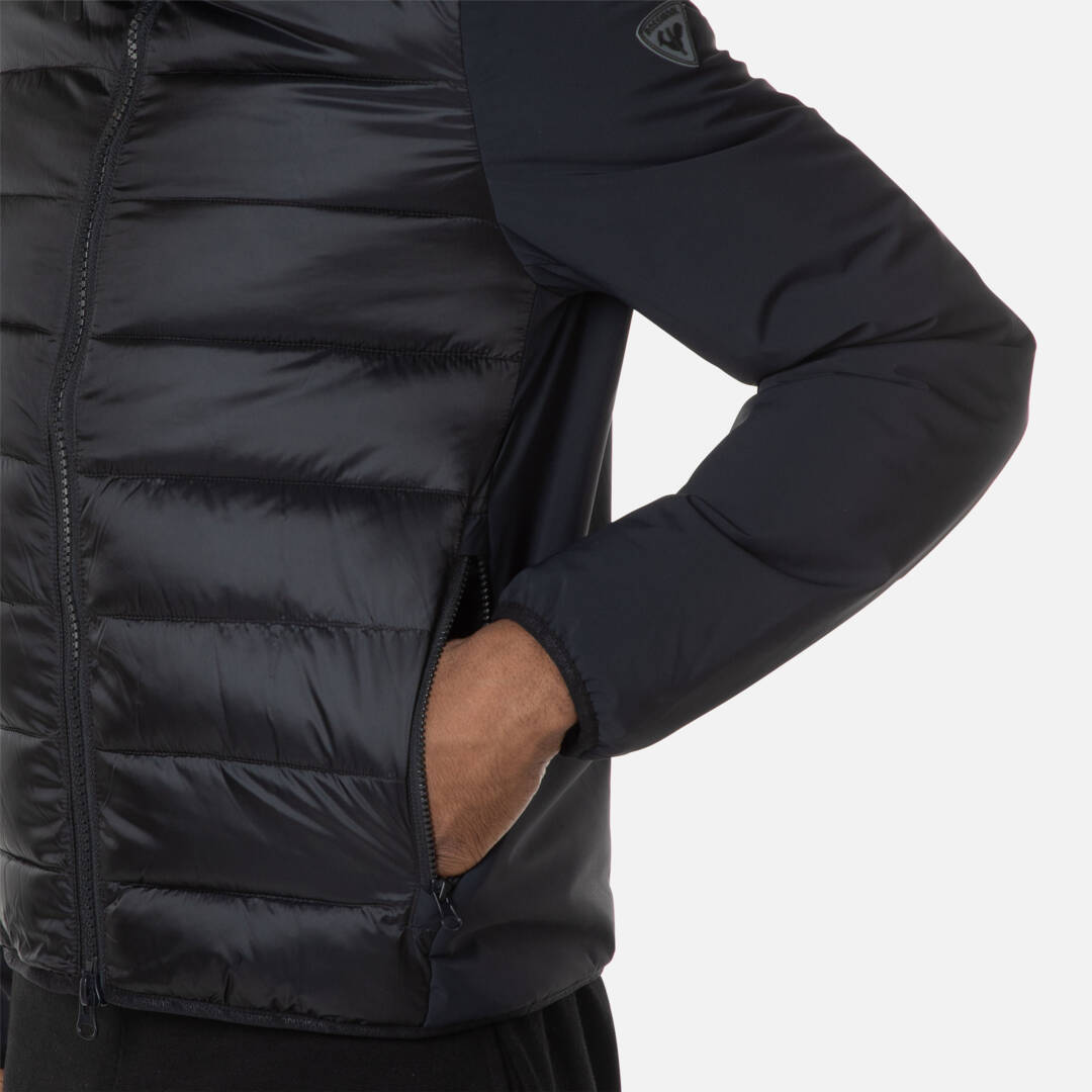 Schwarze Quilt Hoodie Jacke Schwarze Rossignol Stretch Quilt Hoodie Jacke, Detailaufnahme Torso mit Hand in Jackentasche.