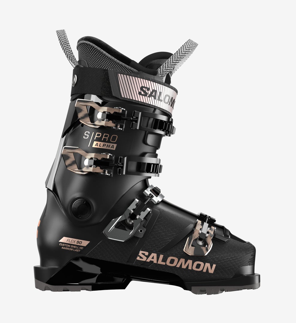 Salomon S/PRO ALPHA 90 W Chaussure de ski noire Salomon S/PRO ALPHA 90 W vue de côté, avec boucles et détails de texte en rose et or.