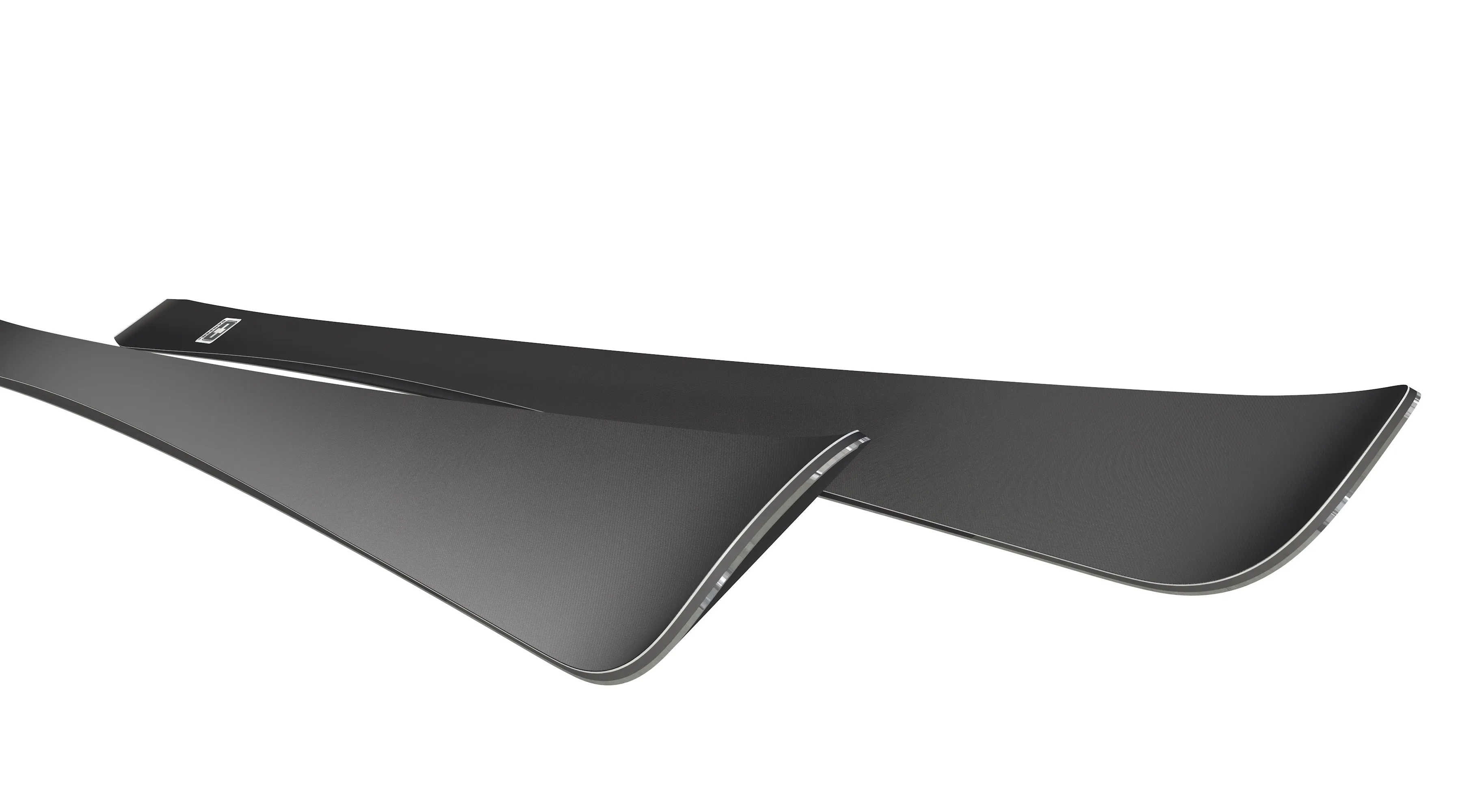 Two black skis lie on top of each other on a white background. The skis are slightly curved.